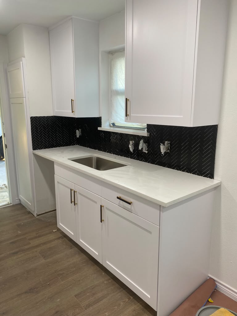 Cocina con backsplash de mármol negro